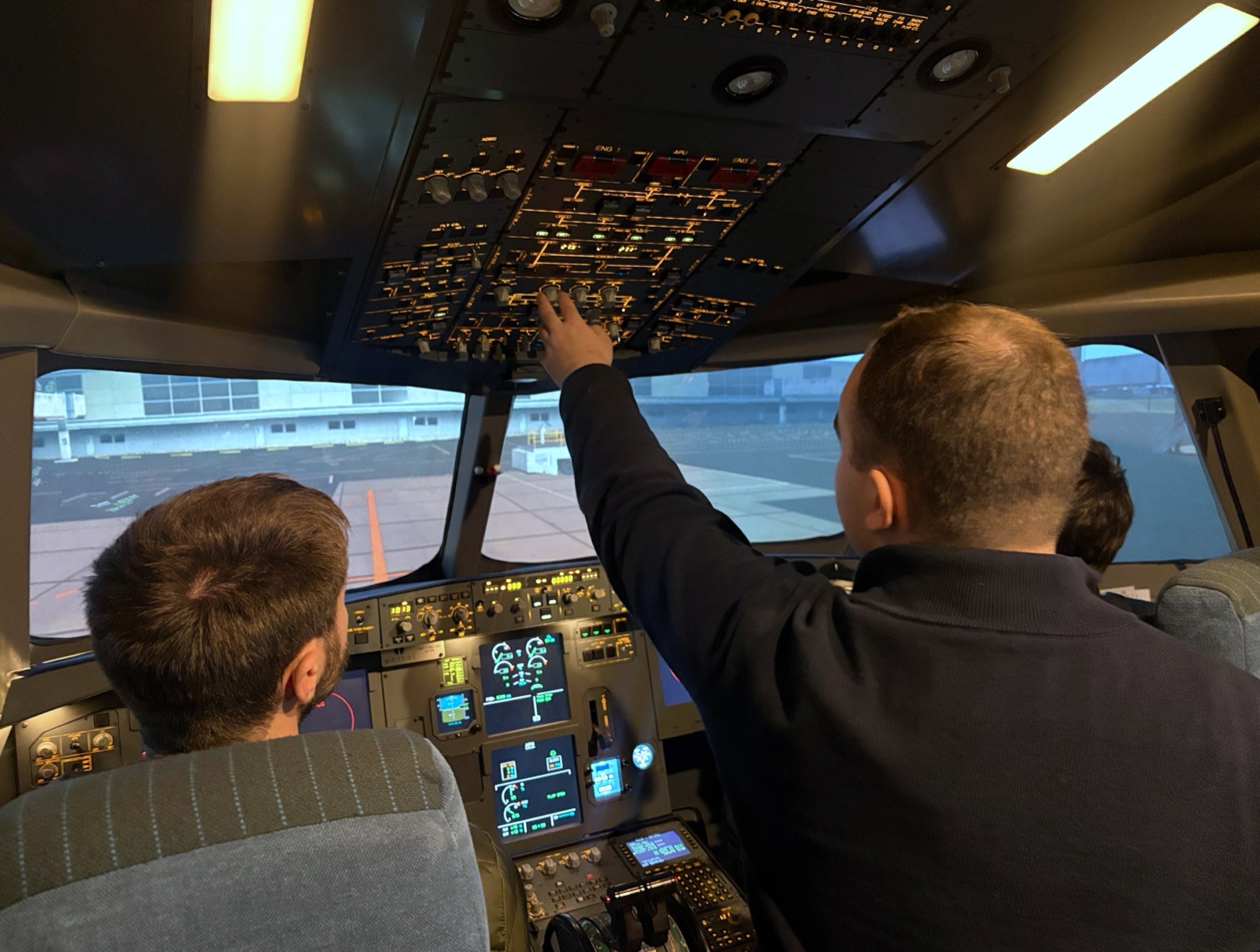 Instructeur montrant le panneau supérieur du simulateur A320